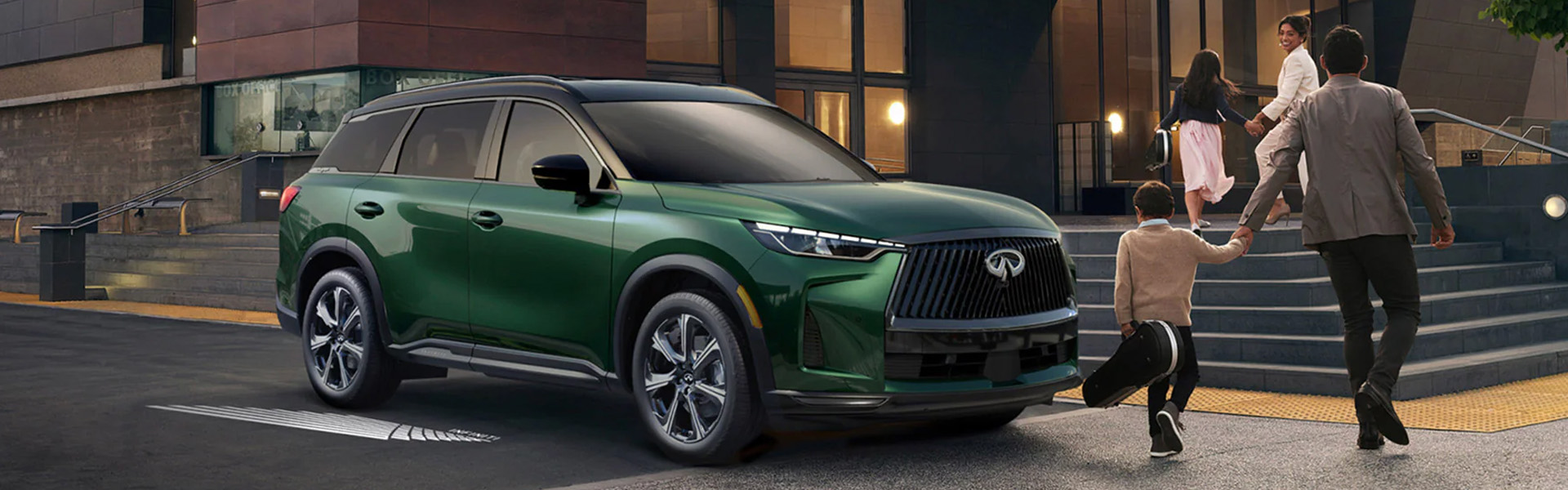 A green 2026 INFINITI QX60 parked outside a building with a family walking toward it.