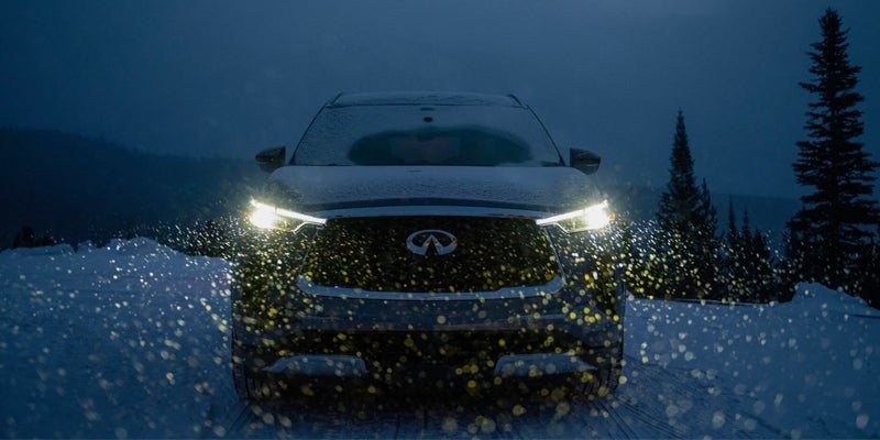 frontal view of an INFINITI in the show with headlights on