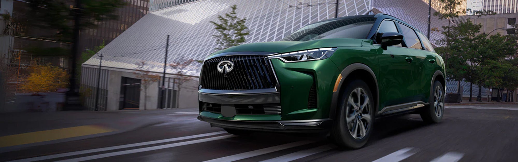 2027 INFINITI QX60 is driving on the road, showcasing its sleek design and modern features.